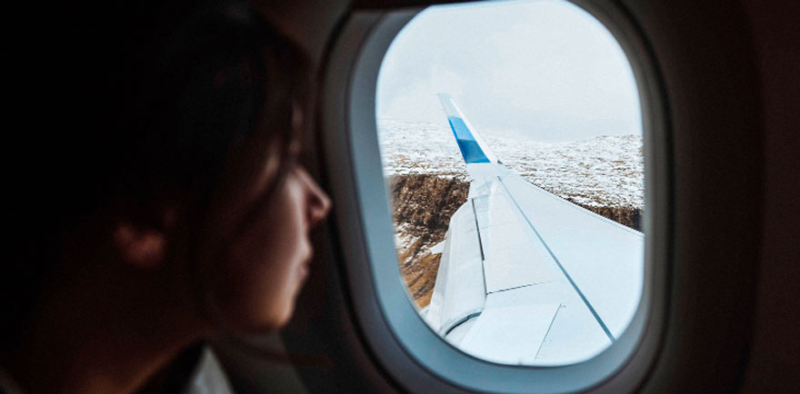 Persona mirando a través de la ventanilla de un avión